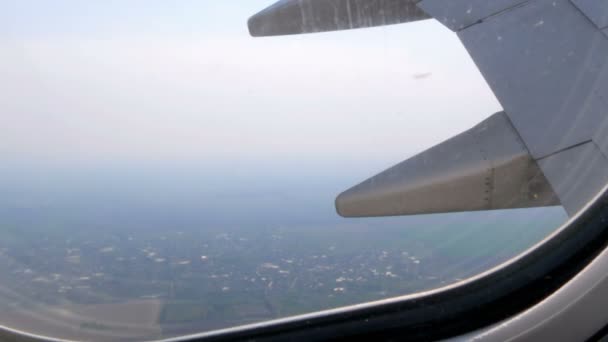 飛行機はヨーロッパのフィールドの上を飛ぶ、 ポートホールの飛行機の翼 — ストック動画