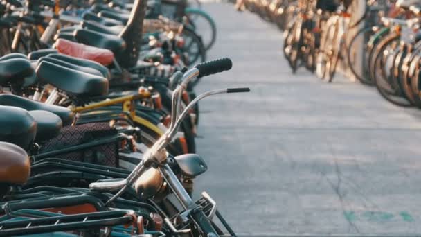 Ámsterdam, Países Bajos - 21 de abril de 2019: Aparcamiento para bicicletas. Muchas bicicletas diferentes estacionadas en una calle en estacionamientos especiales. El problema de la sobrecarga de bicicletas en el país — Vídeos de Stock