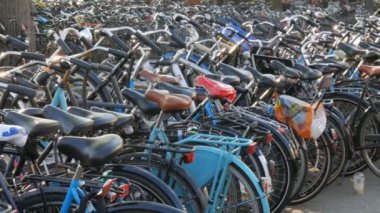 Amsterdam, Hollanda - 21 Nisan 2019: Bisiklet ler için otopark. Birçok farklı bisiklet özel otoparklarda bir sokakta park. Ülkede bisiklet aşırı sorunu