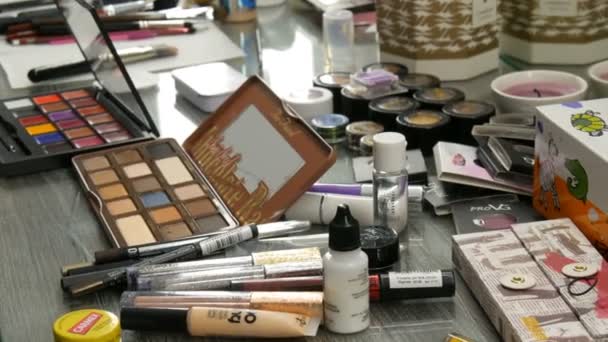 Kamyanskoe, Ukraine - 16. März 2019: Professionelle Kosmetikerin stellt Make-up-Artist auf den Tisch im Studio. Bunter Lippenstift, Schatten, eine Basis in der Make-up-Modebranche — Stockvideo
