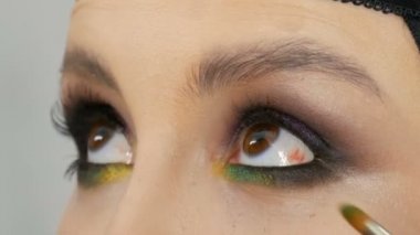 Profesyonel makyaj sanatçısı göz makyajı modeli yapar. Akşam makyajlı yüz modeli. Yakından bak.