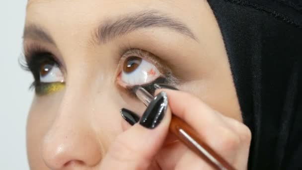 Il truccatore di stilista professionista fa il modello di trucco di occhio. Modello viso con trucco serale vista da vicino — Video Stock