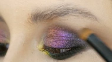 Sarı mor gri gümüş rengi kahverengi gözlü güzel kız modeli göz kapağı üzerinde ile moda çok renkli göz farı bukalemun. Profesyonel kozmetik makyaj. Gözünü kapat görünümü