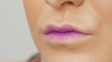 Dudaklar profesyonel makyaj sanatçısı tarafından uygulanan özel fırça ruj ve dudak parlatıcısı ile oluşur. Yüksek moda, kız model dudaklar görünümü kadar yakın