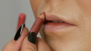 Dudaklar profesyonel makyaj sanatçısı tarafından uygulanan özel fırça ruj ve dudak parlatıcısı ile oluşur. Yüksek moda, kız model dudaklar görünümü kadar yakın