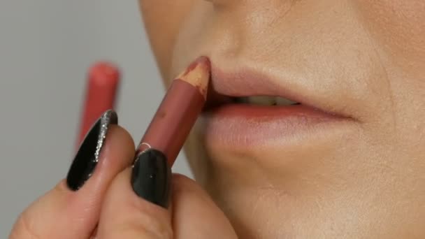 Läpparna är gjorda med speciella borst läppstift och läppglans, som appliceras av professionella makeup-artister. High Fashion, flicka modell läppar närbild Visa — Stockvideo