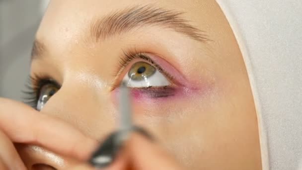 Woman make-up artist stylist gör makeup fashionabla rosa rökiga ögon med speciell makeup borste av ung modell — Stockvideo