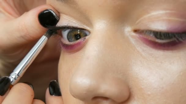 Mujer maquillaje artista estilista hace que el maquillaje de moda rosa ojos ahumados con cepillo de maquillaje especial de modelo joven — Vídeos de Stock