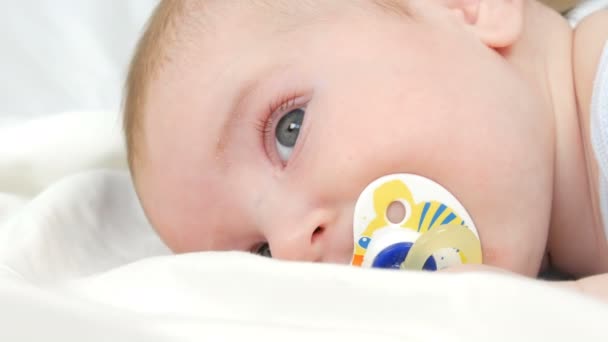 Portrait of beautiful funny little newborn baby of two months lying on white bed — Stock Video