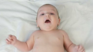 Beyaz yatakta yatan iki aylık güzel komik küçük yenidoğan bebek Portresi