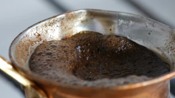 Ferveu o café preto de terra fugitivo em um turk de cobre no fogão a gás branco — Vídeo de Stock