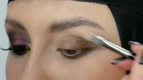 Artista de maquillaje estilista profesional hace modelo de maquillaje de ojos. Modelo de cara con maquillaje de noche vista de cerca — Vídeos de Stock