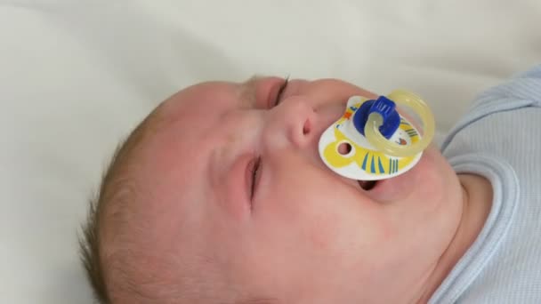 Il neonato di due mesi piange forte con il ciuccio in bocca. Bambino faccia vista da vicino — Video Stock