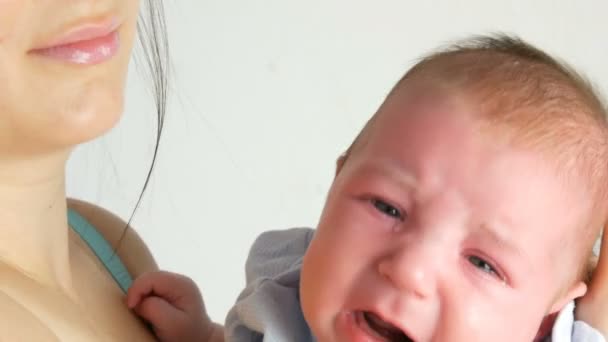 Двухмесячный младенец громко плачет. Детское лицо вблизи — стоковое видео