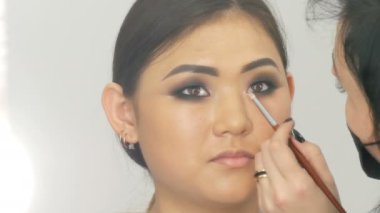Profesyonel makyaj sanatçısı özel fırça ile Koreli kız Asyalı kadın göz makyajı yapar