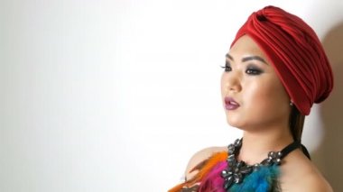 Parlak akşam makyaj dumanlı gözleri ile trendy kırmızı sarık güzel Koreli Asyalı kız beyaz bir arka plan üzerinde stüdyoda poz