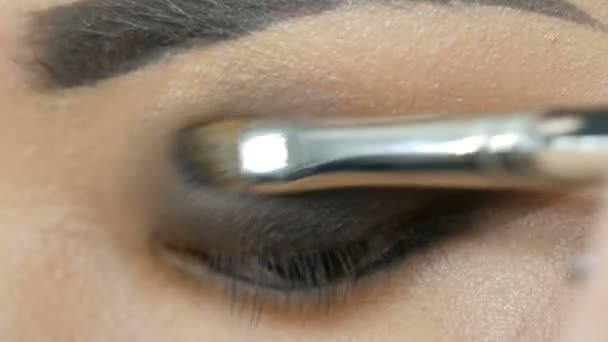 Profesional maquillaje artista hace maquillaje de ojos de chica coreana mujer asiática con cepillo especial — Vídeo de stock