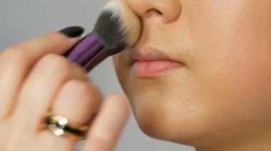 Profesyonel makyaj sanatçısı özel fırça ile Asya Koreli modeller yüz vakıf kapatıcı veya vurgulayıcı uygular