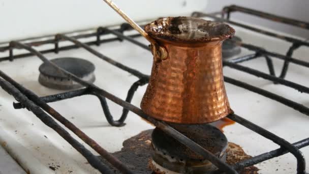 Weggekookt weggelopen gemalen zwarte koffie in een koper Turk op witte gaskachel — Stockvideo