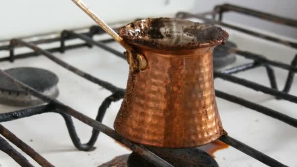 在白色燃气灶上的铜土杯中煮掉失控的黑咖啡 — 图库视频影像