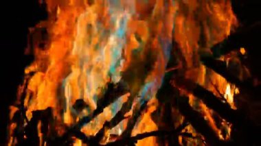 Mistik sihirli gökkuşağı yangın çok renkli alevler renk değiştirir. Şenlik ateşi koyu arka planda birçok renkte yanıyor