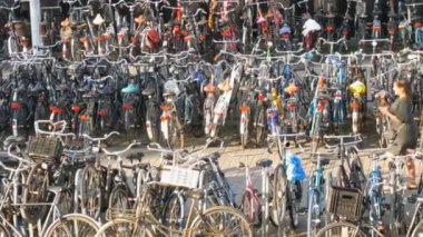 Amsterdam, Hollanda - 21 Nisan 2019: Bisiklet ler için otopark. Birçok farklı bisiklet özel otoparklarda bir sokakta park. Ülkede bisiklet aşırı sorunu