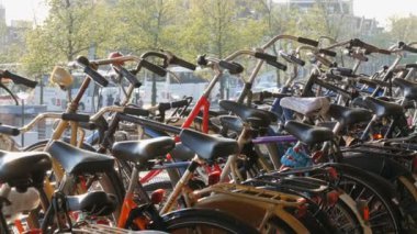 Amsterdam, Hollanda - 21 Nisan 2019: Bisiklet ler için otopark. Birçok farklı bisiklet özel otoparklarda bir sokakta park. Ülkede bisiklet aşırı sorunu