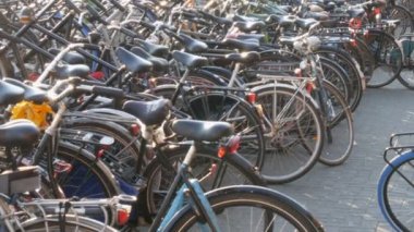 Amsterdam, Hollanda - 21 Nisan 2019: Bisiklet ler için otopark. Birçok farklı bisiklet özel otoparklarda bir sokakta park. Ülkede bisiklet aşırı sorunu