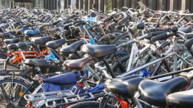 Amsterdam, Hollanda - 21 Nisan 2019: Bisiklet ler için otopark. Birçok farklı bisiklet özel otoparklarda bir sokakta park. Ülkede bisiklet aşırı sorunu