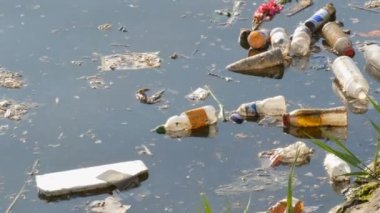 Amsterdam, Hollanda - 21 Nisan 2019: Hollanda'nın başkenti Amsterdam'ın set nehir kanalında çok sayıda çöp, plastik şişe ve kağıt yüzer
