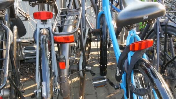 Ámsterdam, Países Bajos - 21 de abril de 2019: Aparcamiento para bicicletas. Muchas bicicletas diferentes estacionadas en una calle en estacionamientos especiales. El problema de la sobrecarga de bicicletas en el país — Vídeo de stock