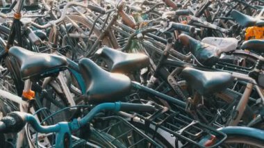 Amsterdam, Hollanda - 21 Nisan 2019: Bisiklet ler için otopark. Birçok farklı bisiklet özel otoparklarda bir sokakta park. Ülkede bisiklet aşırı sorunu