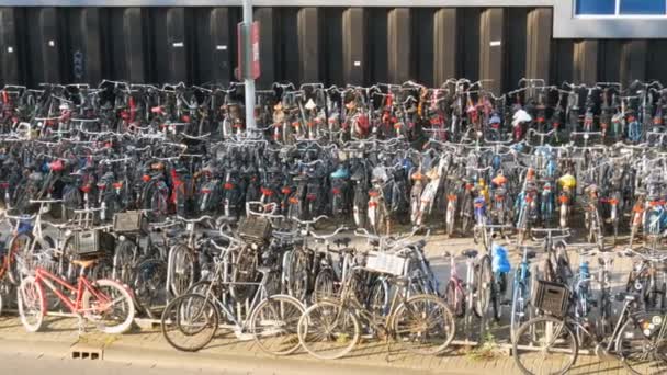 Ámsterdam, Países Bajos - 21 de abril de 2019: Aparcamiento para bicicletas. Muchas bicicletas diferentes estacionadas en una calle en estacionamientos especiales. El problema de la sobrecarga de bicicletas en el país — Vídeo de stock