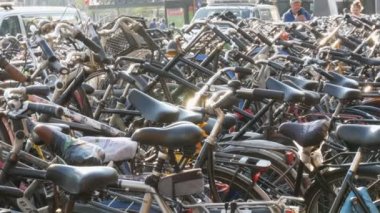 Amsterdam, Hollanda - 21 Nisan 2019: Bisiklet ler için otopark. Birçok farklı bisiklet özel otoparklarda bir sokakta park. Ülkede bisiklet aşırı sorunu