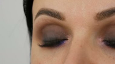 Makyöz, özel fırça fırçası leylak, göz farı, göz farı ve kadının yakın görüş açısıyla mankenlere dumanlı gözler yapıyor. Profesyonel yüksek moda.