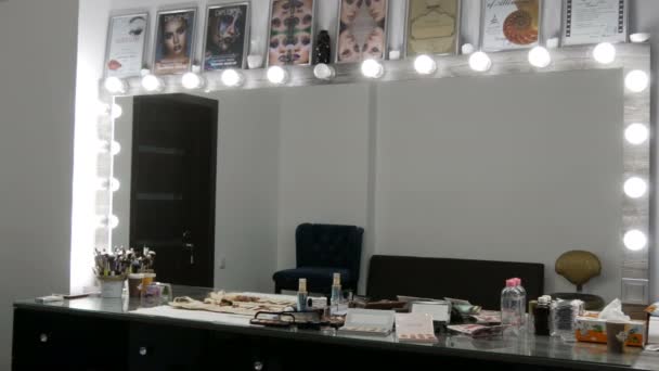20 september 2019 - Kamenskoye, Oekraïne: Speciale spiegel en tafel voor professionele make-up in een schoonheidssalon met verschillende make-up cosmetica paletten op tafel in beauty studio. Oogschaduw, make-up — Stockvideo
