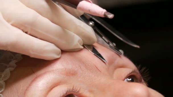 Un dispositivo especial para la medición correcta de la forma de las cejas, brújulas. esteticista hace una nueva forma de cejas para un cliente en el viejo tatuaje descolorido. Nuevas tenologías en cosmetología — Vídeo de stock