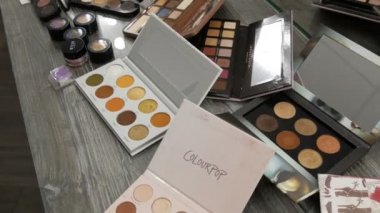 20 Eylül 2019 - Kamenskoye, Ukrayna: Güzellik stüdyosundaki bir masanın üzerinde çeşitli makyaj kozmetik paletleri. Göz farı, makyaj temeli, ruj.