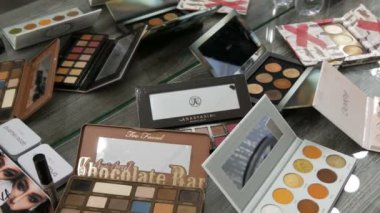 20 Eylül 2019 - Kamenskoye, Ukrayna: Güzellik stüdyosundaki bir masanın üzerinde çeşitli makyaj kozmetik paletleri. Göz farı, makyaj temeli, ruj.