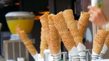 İstanbul, Türkiye - 12 Haziran 2019: Sokak büfesinde bir dondurma satıcısı alıcıya kırmızı dondurmalı waffle veriyor. Yaz havası kavramı. Waffle bardağında dondurma satışı