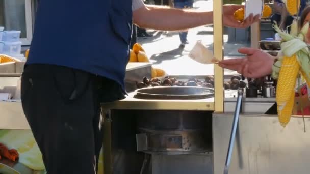 Koper geeft geld aan verkoper. Verse maïs op de kiosk toonbank. Straat voedsel, verkoper verkoopt gekookte maïs op een rij aan klanten in een stad straat. Gezonde voeding en producten Concept — Stockvideo