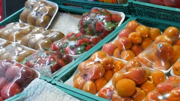 Perziken, nectarine, abrikozen, aardbeien, kiwi op straat markt teller onder speciale cellofaan doek, beschermd tegen stof en vocht. — Stockvideo
