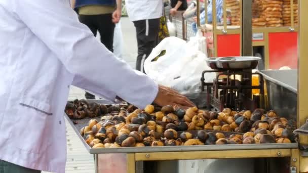 Istanbul, Turkije - 12 juni 2019: Geroosterde kastanjes op straat. Straat eten, de hete gekookte kastanjes — Stockvideo