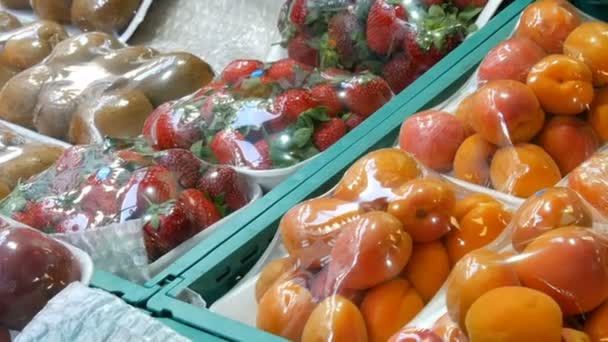 Broskve, Nektarinky, meruňky, jahody, kiwi na pouliční tržnici pod speciální celofánovou látkou, chráněné před prachem a vlhkostí. — Stock video