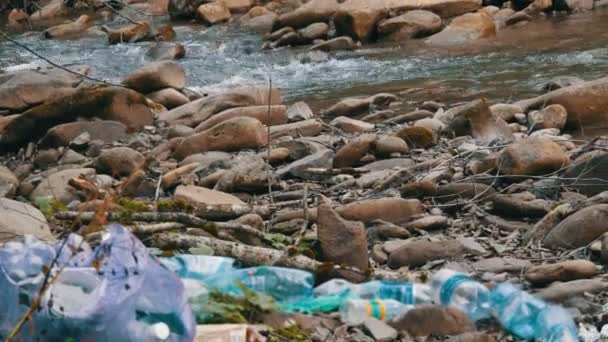 Montagna veloce flusso pulito, sulla riva rocciosa, che ha spazzatura, bottiglie di plastica, borse. Il fattore umano nell'inquinamento ambientale. Sfocatura speciale della spazzatura — Video Stock