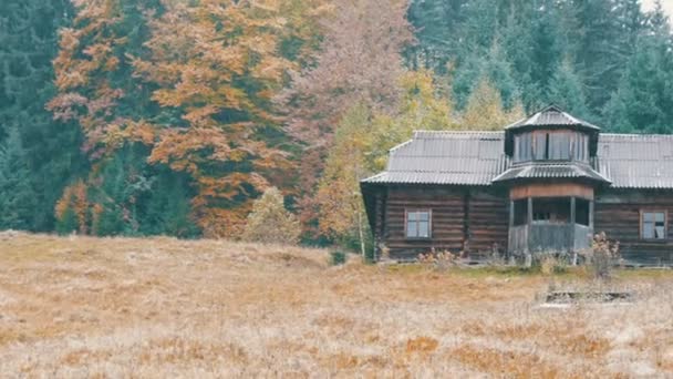 Pierwszy śnieg wczesną jesienią na tle starego drewnianego opuszczonego domu z wybitymi oknami jesienią. Opuszczony dom w Karpatach w październiku — Wideo stockowe