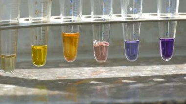 Eski bir laboratuvarda renkli sıvı su içeren renkli test tüpleri. Kapat..