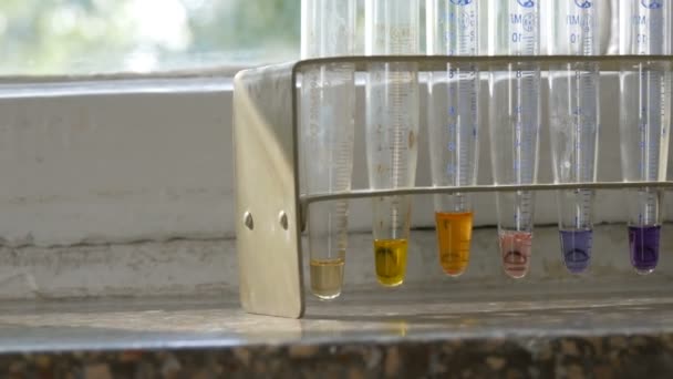 Kleur vloeibaar water in medische reageerbuizen in het laboratorium op oud raam met marmeren vensterbank. — Stockvideo