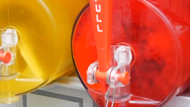 Соковижималка з крижаним соком, що містить ряд червоних і жовтих слимаків, які готуються в шматочках машин на ринку вуличних продуктів харчування — стокове відео