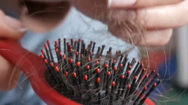 Close up widok kobiet ręce czyste Drop down włosy na grzebień po czesaniu. Dużo włosów na grzebieniu. Utrata włosów, niewydolność hormonalna, stres, dieta, choroba głowy i cebulki włosów — Wideo stockowe